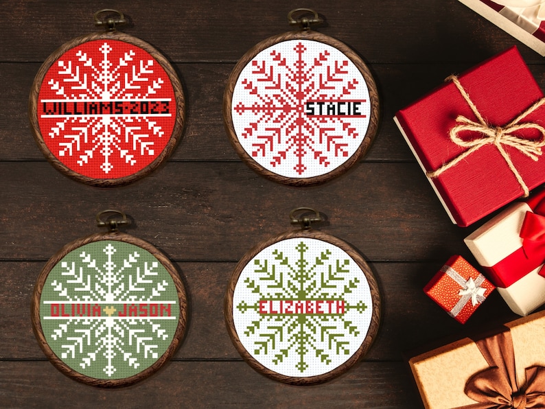 May include: Four personalised Christmas baubles with snowflake designs. The baubles are in wooden hoops with red, white and green embroidery. The names "Williams 2023", "Stacie", "Olivia & Jason", and "Elizabeth" are embroidered on the baubles.
