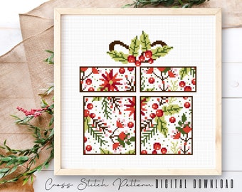 May include: A cross stitch pattern of a Christmas gift box with a red and green floral design. The pattern is framed in a wooden frame and is ready to be stitched.