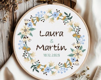 Puede incluir: Un patrón de punto de cruz con una corona de flores con los nombres Laura & Martin y la fecha 10.12.2025.