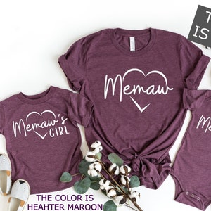May include: Three heather maroon t-shirts with white text. The largest shirt says "Memaw" with a heart. The smaller shirts say "Memaw's Girl" and "Memaw's Boy".
