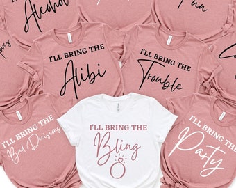 May include: Set of nine pink and white t-shirts with black text. Each shirt says "I'll bring the" followed by a different phrase. The phrases are: "Dance Moves", "Alcohol", "Your Text", "Fun", "Alibi", "Trouble", "Bad Decisions", "Bling", "Laughs", "Party".