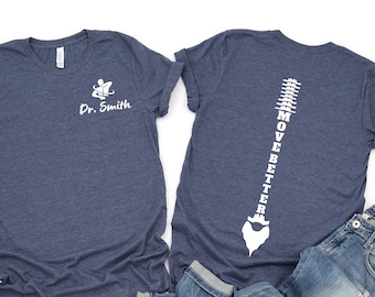 May include: Two heather navy blue t-shirts. One shirt has the text "Dr. Smith" on the front. The other shirt has a white outline of a spine with the text "Move Better" on the back.