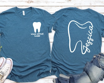 May include: Two teal blue t-shirts with a white tooth graphic. One shirt says "Your Office Name" and the other says "Jessica". The color is Heather Deep Teal.