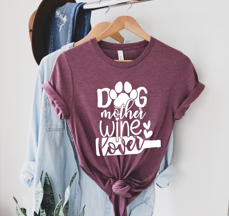 May include: A maroon t-shirt with the text "Dog mother wine lover" in white with a paw print and wine bottle graphic.