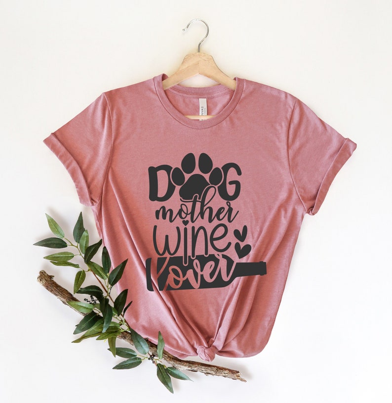 May include: A dusty rose t-shirt with a black graphic that says "Dog mother wine lover" with a paw print and a wine bottle.