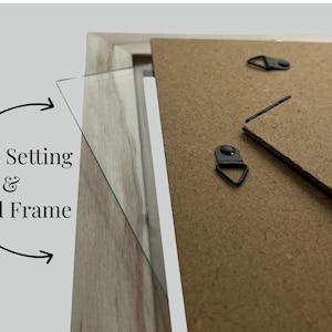 May include: Close-up of a wooden picture frame with a glass setting. The back of the frame is visible, showing hanging hardware. Text on the image reads "Glass Setting & Wood Frame."