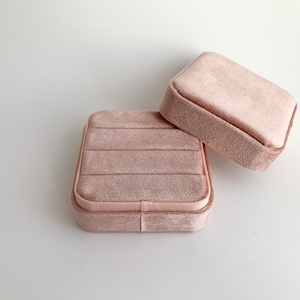 May include: Two pink velvet jewellery boxes with a ribbed interior. The boxes are stacked on top of each other.