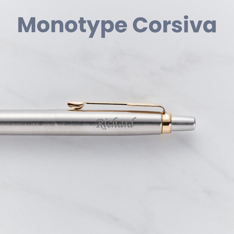 May include: A silver pen with a gold clip and a gold band near the tip. The pen is engraved with the name "Richard".