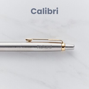 May include: A silver pen with a gold clip and a gold band at the end. The pen is engraved with the name "Richard".