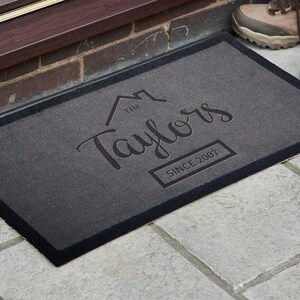 May include: A gray welcome mat with black trim featuring the text "The Taylors Since 2007" in a stylized font.