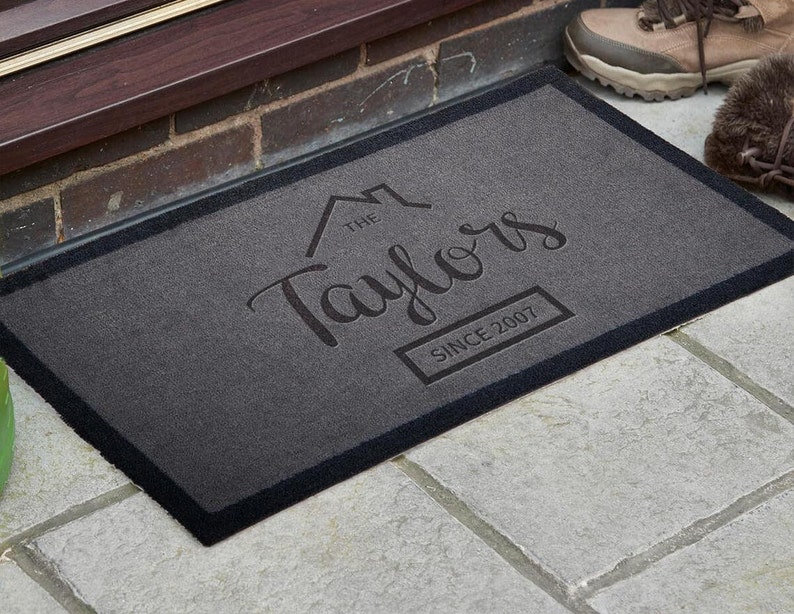 May include: A gray welcome mat with black trim featuring the text "The Taylors Since 2007" in a stylized font.