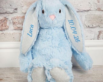 May include: A light blue plush rabbit with long ears featuring a grey and white polka dot pattern on the inner side. The left ear is embroidered with the name Luca in blue, and the right ear displays the date 10.04.26 in blue embroidery.