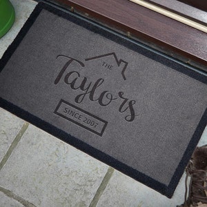May include: Gray welcome mat with black border and the text "The Taylors Since 2007" in a stylized font.