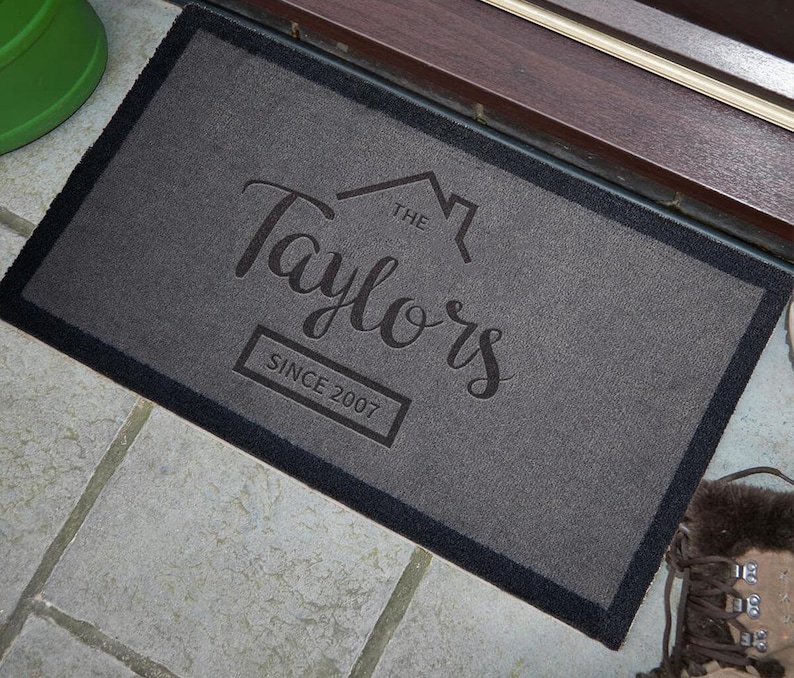 May include: Gray welcome mat with black border and the text "The Taylors Since 2007" in a stylized font.