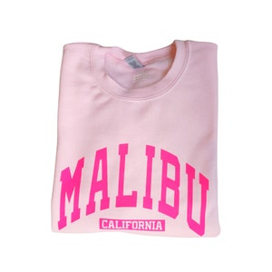 Op de afbeelding: Roze sweatshirt met een roze "MALIBU CALIFORNIA" print.