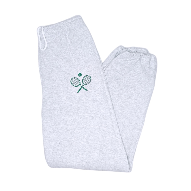 May include: Gray sweatpants with a green tennis racket and ball design.