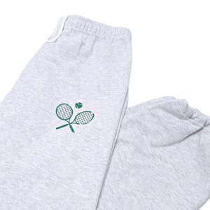May include: Gray sweatpants with a green tennis racket and ball graphic.