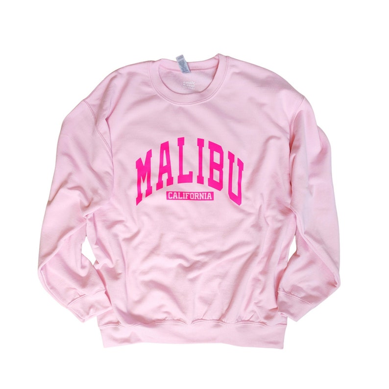 Op de afbeelding: Roze sweatshirt met een roze "MALIBU CALIFORNIA" afbeelding.
