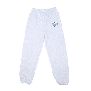 May include: Gray sweatpants with a green tennis racket and ball design on the left leg.