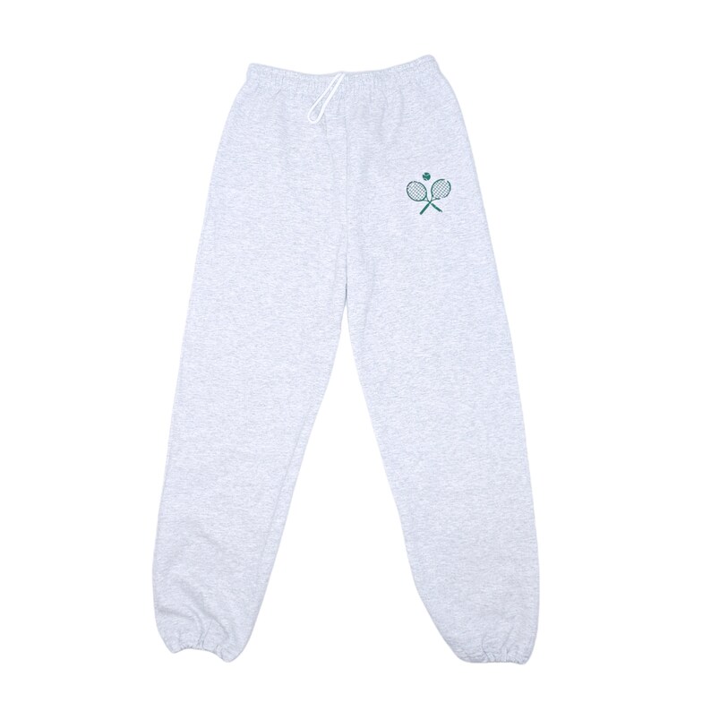 May include: Gray sweatpants with a green tennis racket and ball design on the left leg.