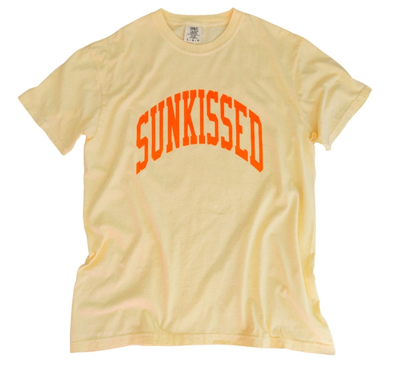 May include: A yellow t-shirt with an orange arch design that says "SUNKISSED".