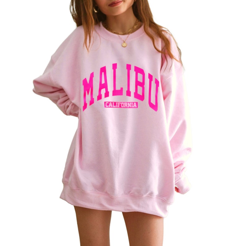 Op de afbeelding: Roze sweatshirt met een grote roze print van "MALIBU CALIFORNIA".