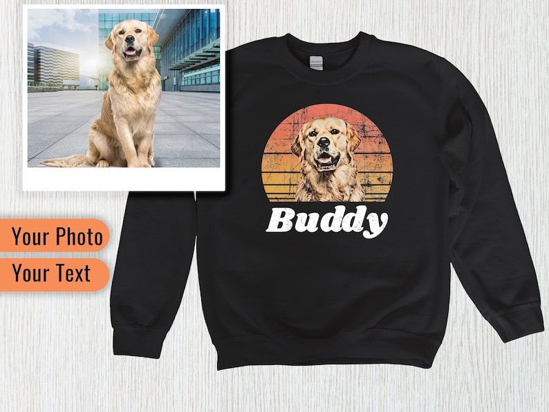 May include: Black sweatshirt with a vintage-style sunset graphic featuring a golden retriever dog. The text 'Buddy' is printed below the graphic.