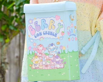 May include: A light blue backpack with the text "Berry Cow Crunch" and illustrations of cartoon cows having a picnic. The bag has a rectangular shape, a top flap, and light blue straps. The background is a green field with flowers.