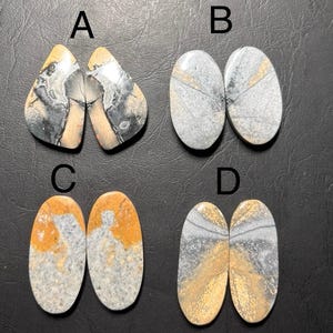 May include: A white ceramic mug with a black handle and the text "But First, Coffee" in a black, handwritten-style font. The mug is on a white surface.