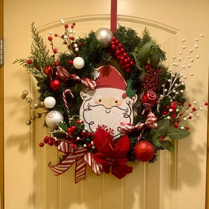 魅力的なカラフルなクリスマスリース、ホリデーリース、冬のリース、緑のモミのリース、サンタクロースのリース、玄関のリース