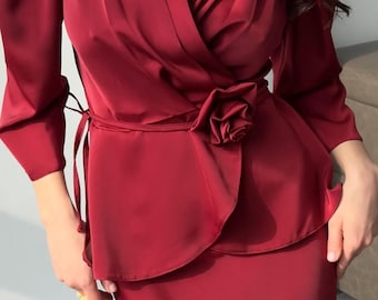 May include: A burgundy-colored two-piece outfit. The top features a wrap design with a rose detail at the waist and long sleeves. The skirt is a matching burgundy color. The text "Elena Kosminskaya" is visible on the skirt.