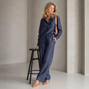 Conjunto de dos piezas de algodón azul marino, camisa abotonada, pantalón con cinturón, atuendo minimalista.