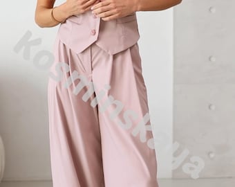 May include: A light pink sleeveless vest and wide-leg pants set. The vest has a button-up front and a V-neck. The pants are high-waisted and flowy. The outfit is made of a soft, solid-colored fabric, perfect for a business casual look.