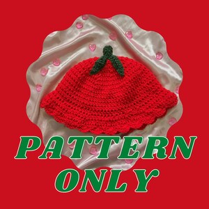 May include: A crochet pattern for a red strawberry-shaped bucket hat with green leaves. The pattern is available for purchase, but the hat itself is not included. The text "PATTERN ONLY" is displayed on the image.