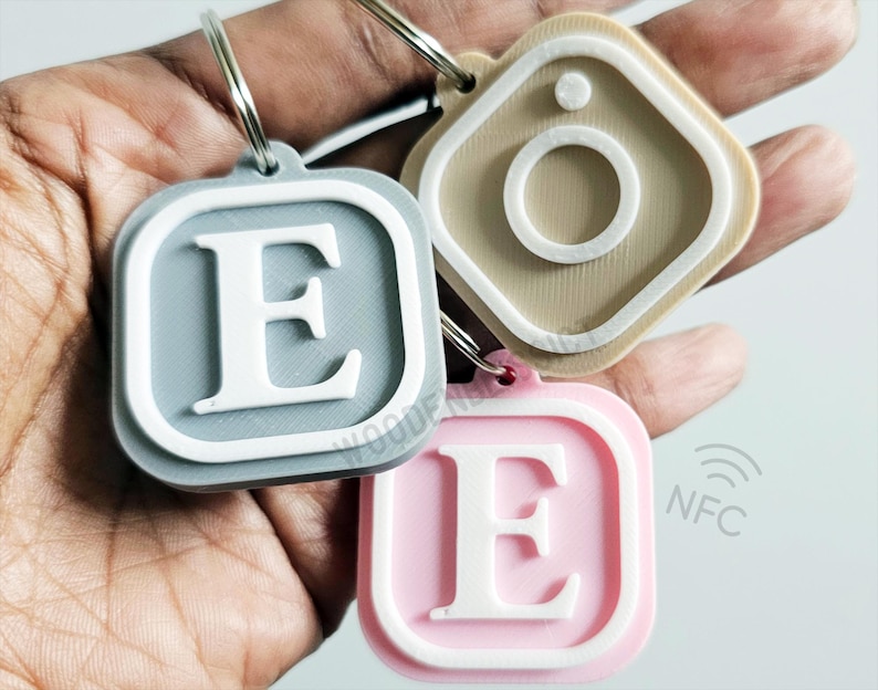 Pu&ograve; includere: Tre portachiavi con un anello argentato. Il primo portachiavi &egrave; grigio con una lettera E bianca. Il secondo portachiavi &egrave; rosa con una lettera E bianca. Il terzo portachiavi &egrave; beige con un cerchio bianco al centro.