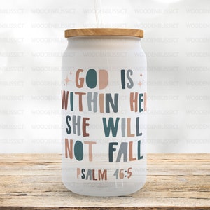 Puede incluir: Un vaso blanco con tapa de madera y una cita que dice "Dios está en ella, no caerá, Salmo 46:5". La cita está en una fuente colorida con acentos marrones, azul verdoso y rosados.