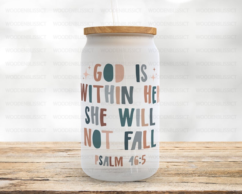 Puede incluir: Un vaso blanco con una tapa de madera y una cita que dice "Dios est&aacute; en ella, no caer&aacute;, Salmo 46:5". La cita est&aacute; en una fuente colorida con un esquema de color turquesa, rosa y marr&oacute;n.