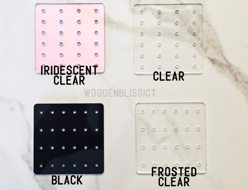 May include: Four earring display boards with different colors and finishes: iridescent clear, clear, black, and frosted clear. Each board has a grid of small holes for holding earrings.
