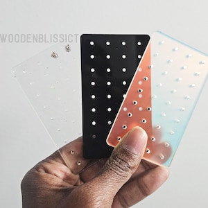 Puede incluir: Tres tarjetas de exhibición de aretes con agujeros para guardar aretes. Las tarjetas son transparentes, negras e iridiscentes.