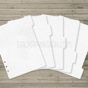 May include: Five white divider pages for a disc bound planner. The pages have a grid pattern and are designed to be used as section dividers.