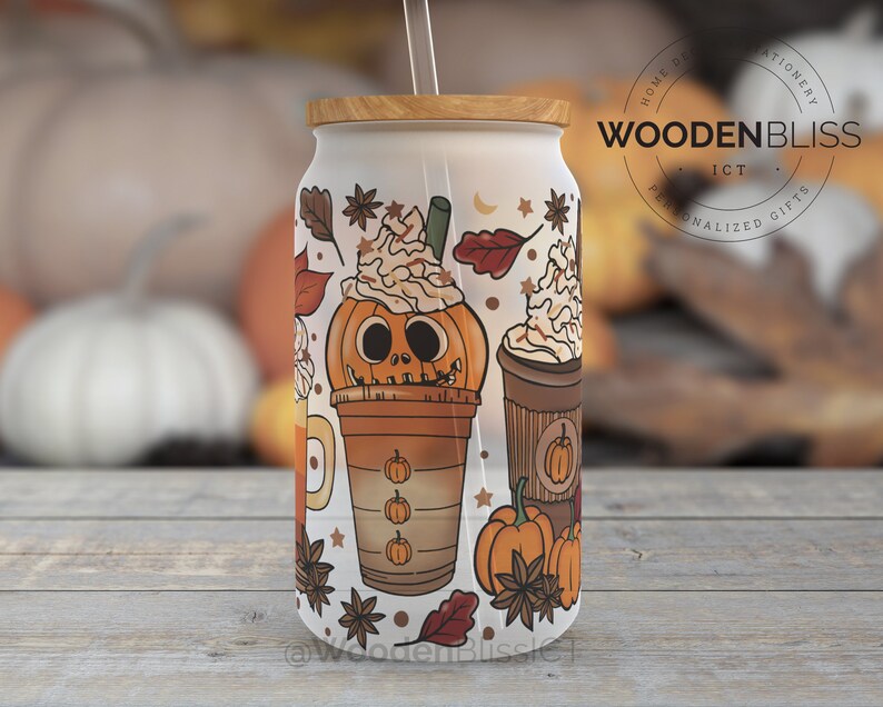 May include: White reusable tumbler with a fall-themed design featuring pumpkins, leaves, and coffee cups. The tumbler has a wooden lid and a straw. The text "WOODENBLISS" is printed on the tumbler.
