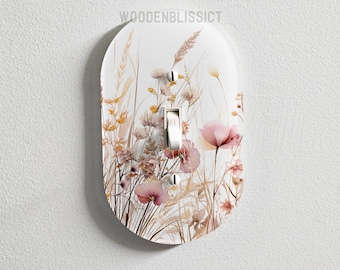 May include: A white light switch cover with a floral design featuring pink and brown flowers and tall grasses. The design is reminiscent of a wildflower meadow.