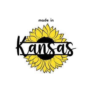 May include: A yellow sunflower with a black center and the text "made in Kansas" written in a black script font.