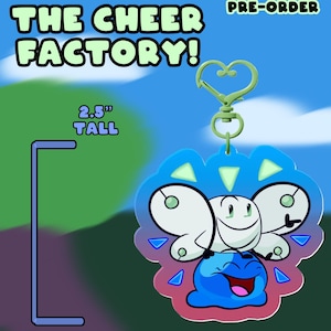 May include: A 2.5-inch tall keychain featuring a cartoon character with a white body and a blue base. The keychain has a heart-shaped clasp and the text "THE CHEER FACTORY!" in a bubble font.