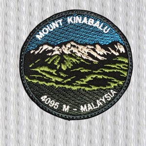 Pode incluir: Patch bordado circular com o Monte Kinabalu, Malásia. O patch tem uma borda preta e mostra uma cordilheira com céu azul, terreno verde e o texto "MOUNT KINABALU" e "4095 M - MALAYSIA".