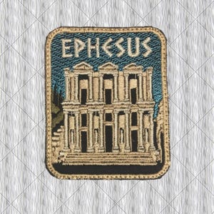 May include: Embroidered patch featuring the word "EPHESUS" above a detailed depiction of the Library of Celsus in Ephesus. The patch has a rectangular shape with a gold border, blue background, and tan and black details.
