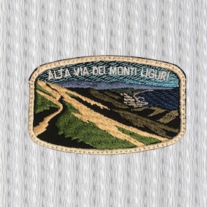 May include: Embroidered patch featuring a landscape scene with the text "ALTA VIA DEI MONTI LIGURI". The patch has a rectangular shape with a gold border. The landscape depicts a winding path, hills, and a coastal view with blue and green hues.