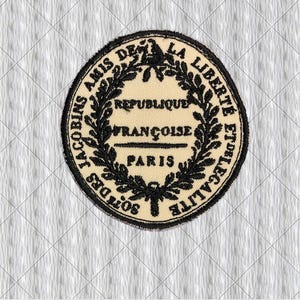 May include: A circular patch with black embroidered text and a laurel wreath design. The text reads "JACOBINS AMIS DE LA LIBERTE ET DE L'EGALITE" and "REPUBLIQUE FRANÇOISE PARIS". The patch is on a cream-colored background.