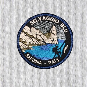 May include: Embroidered patch with a circular design featuring a coastal landscape. The patch includes the text "SELAVGGIO BLU SARDINIA - ITALY" in a curved font. The design incorporates shades of blue, beige, and black.