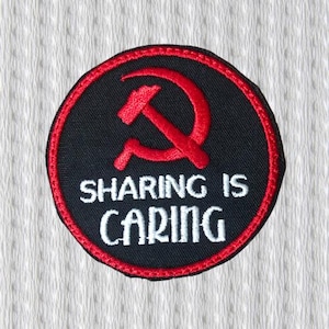 Może przedstawiać: Okrągła czarna naszywka z czerwonym symbolem młota i sierpa oraz czerwoną obwódką. Biały tekst na naszywce brzmi "SHARING IS CARING". Naszywka znajduje się na białym, teksturowanym tle.